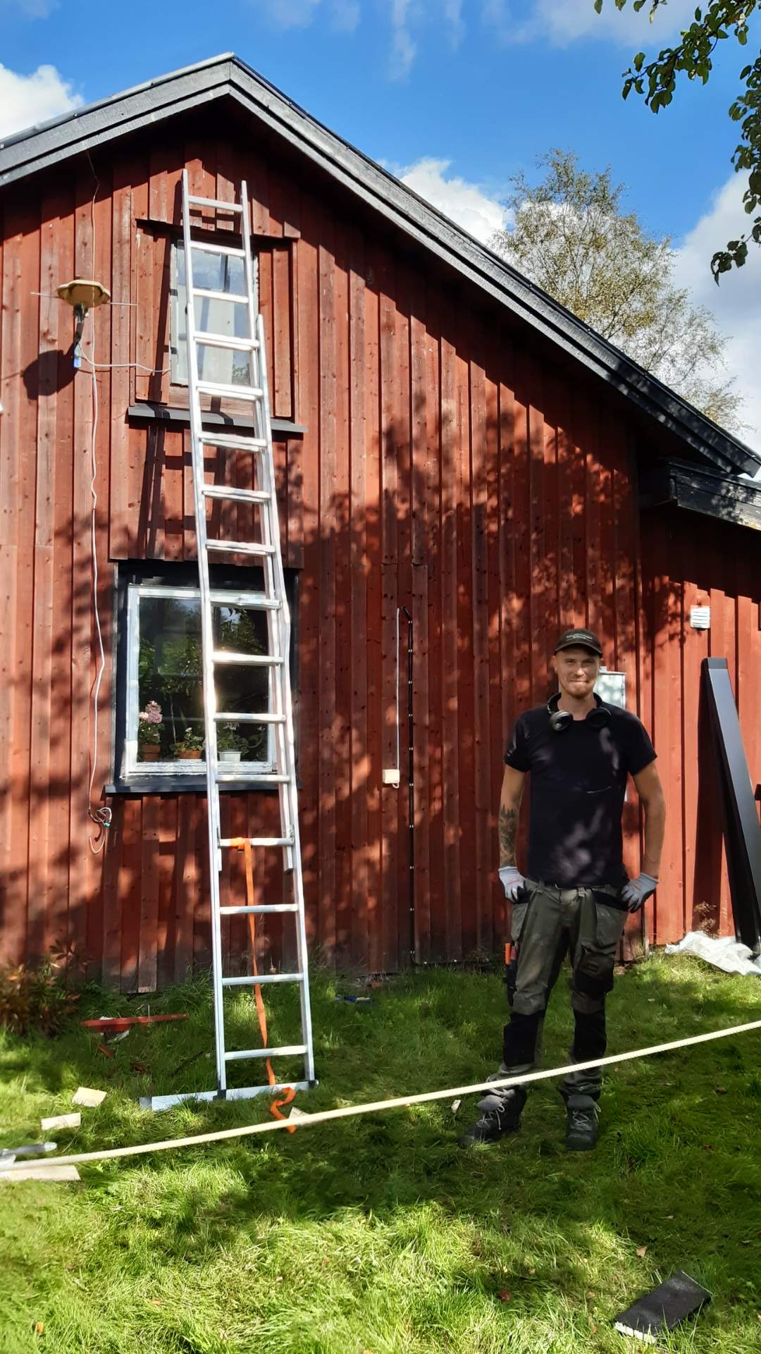 Marcus, snickare på Hederligt Hantverk, framför en röd lada på Österlen